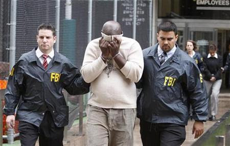 Emmanuel Roy, a suspect in a mortgage-fraud scheme is escorted by FBI agents after being taken into custody in New York, October 15, 2009. REUTERS/Brendan McDermid