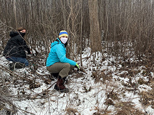two female volunteers in face masks in snowy forest