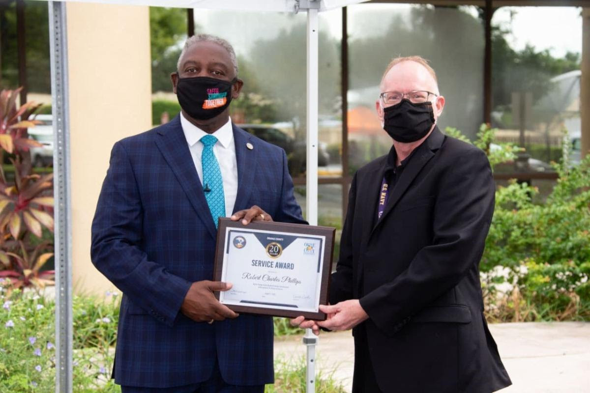 LinkedIn Post - Mayor Demings handing an employee a service award plaque