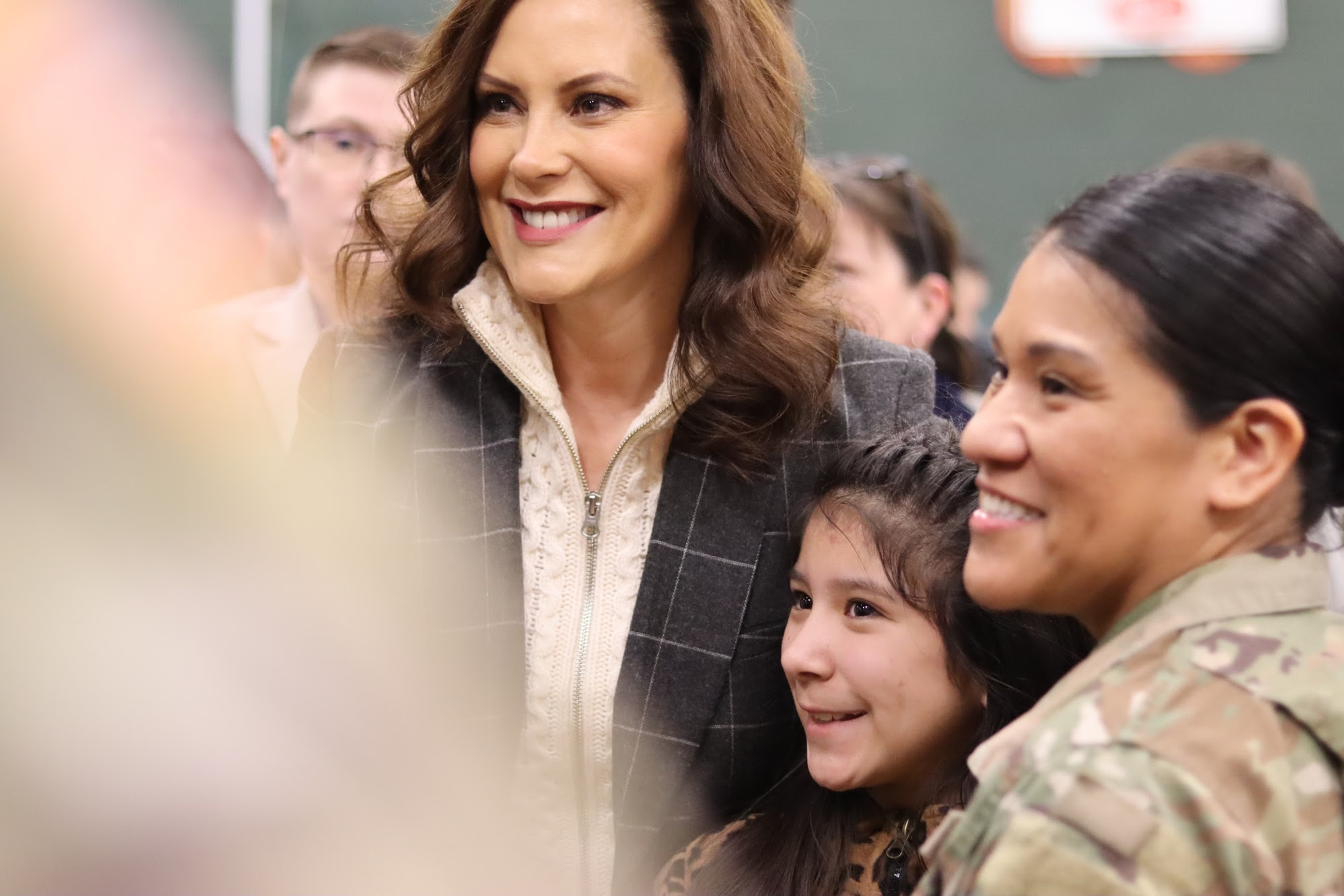Gov. Whitmer poses with a soldier and family 