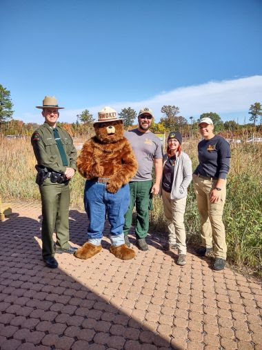 Ranger, Smokey Bear, and Albany Pine Bush staff pose outside for a photo