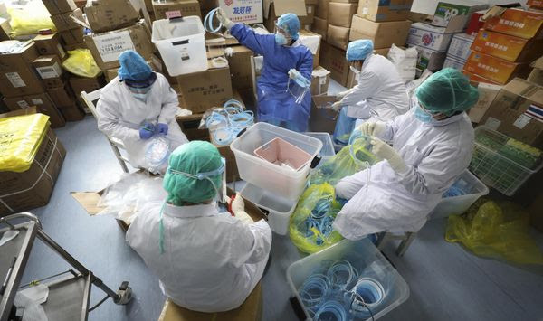 Nurses assemble plastic face shields at a hospital designated for the coronavirus patients in Wuhan in central China&#39;s Hubei province, Sunday, March 1, 2020. New York confirmed Sunday the state&#39;s first positive test of the new virus that has sickened tens of thousands of people across the globe. (Chinatopix via AP)