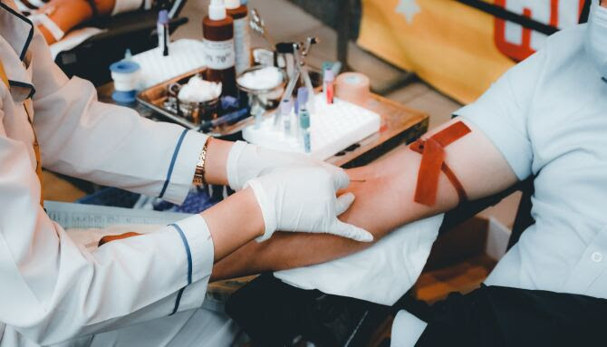 A medical professional drawing blood from a patient's arm