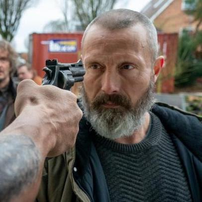 A gun is pointed at Mads Mikkelsen's head