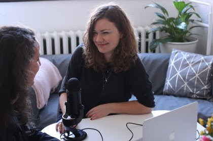 a an image of two women talking with microphone between them