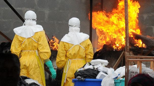 PHOTO: Health care workers wearing full body suits burn infected items at the ELWA Hospital in Monrovia on Aug. 30, 2014. 