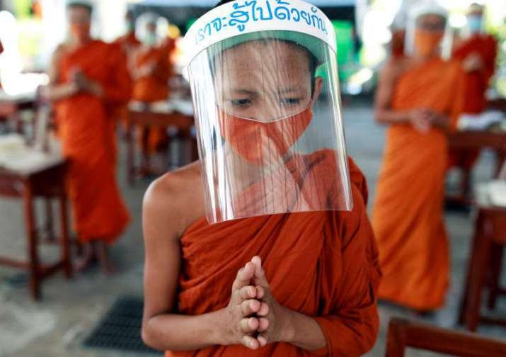 Novice monks wear face shields and protective masks during a lesson at the Wat Molilokkayaram monastic educational institute in Bangkok. From bangkokpost.com