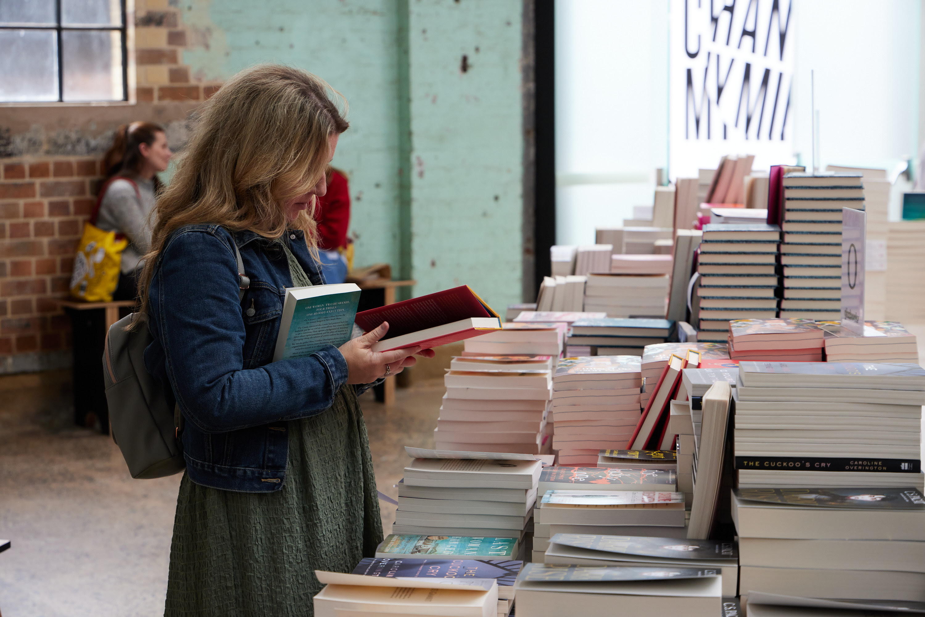 A woman reading a book at the 2021 Sydney Writers' Festival bookstore