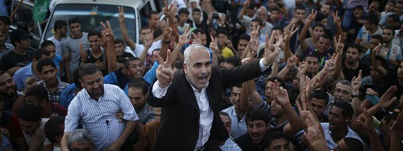 Portavoz de Hamas, Fawzi Barhoum, celebra junto a palestinos el anuncio del alto el fuego en Gaza. Foto: Reuters.
