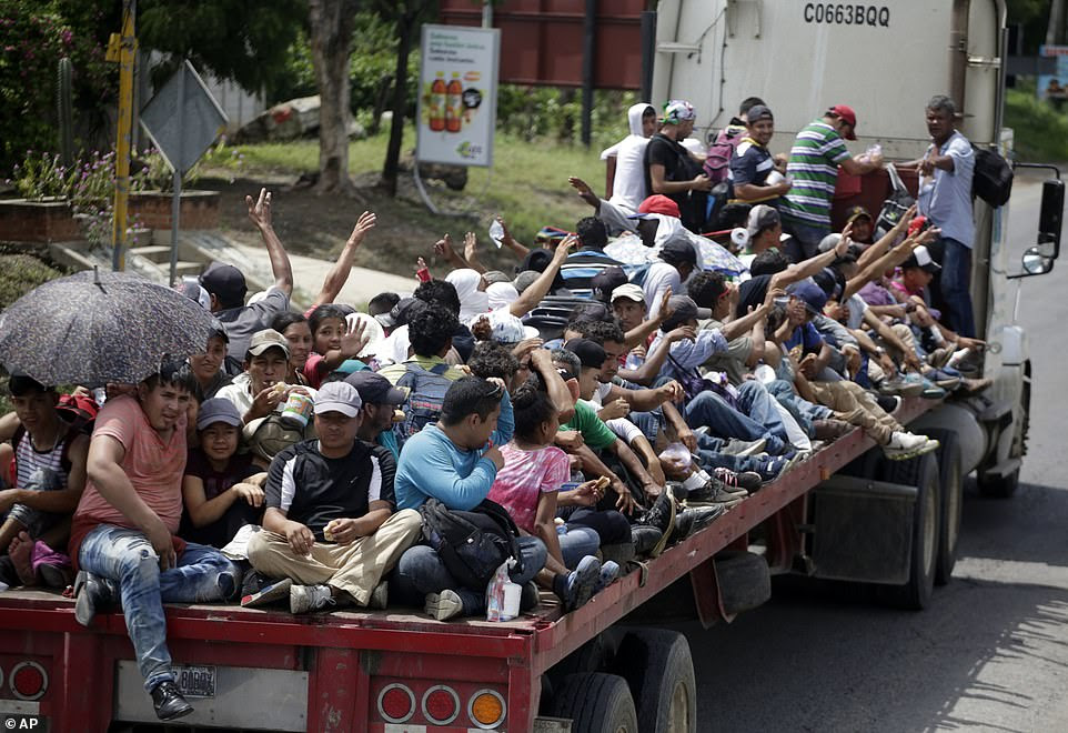 Honduran migrants  get a free ride in the back of a trailer tru