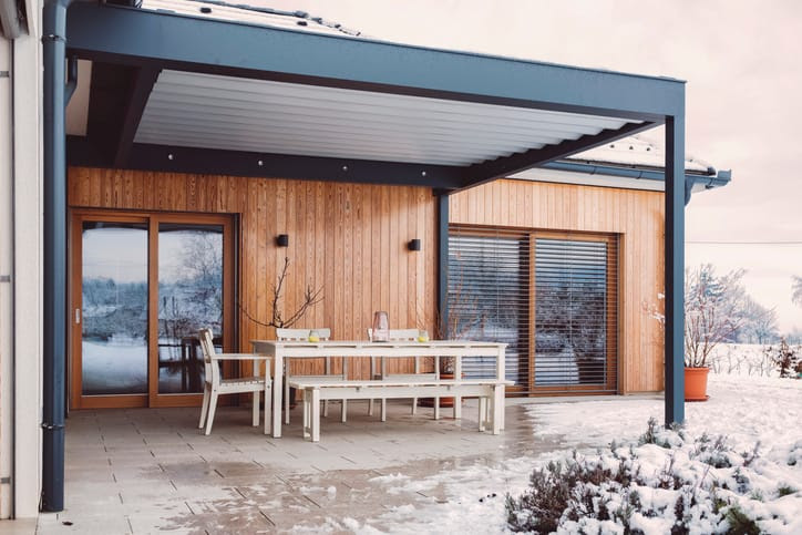 Covered outdoor patio surrounded by snow and ice on the ground.
