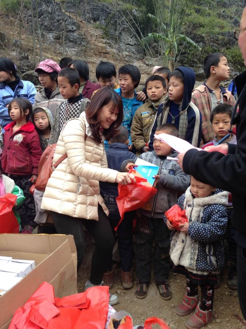 Xiaoling Mai giving out shoes and clothes to the Lin Wang Students
