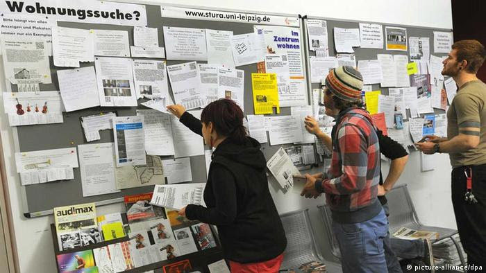 Studenten an der Universität in Leipzig informieren sich am «schwarzen Brett» über Wohnungsangebote. Foto: Waltraud Grubitzsch/dpa 