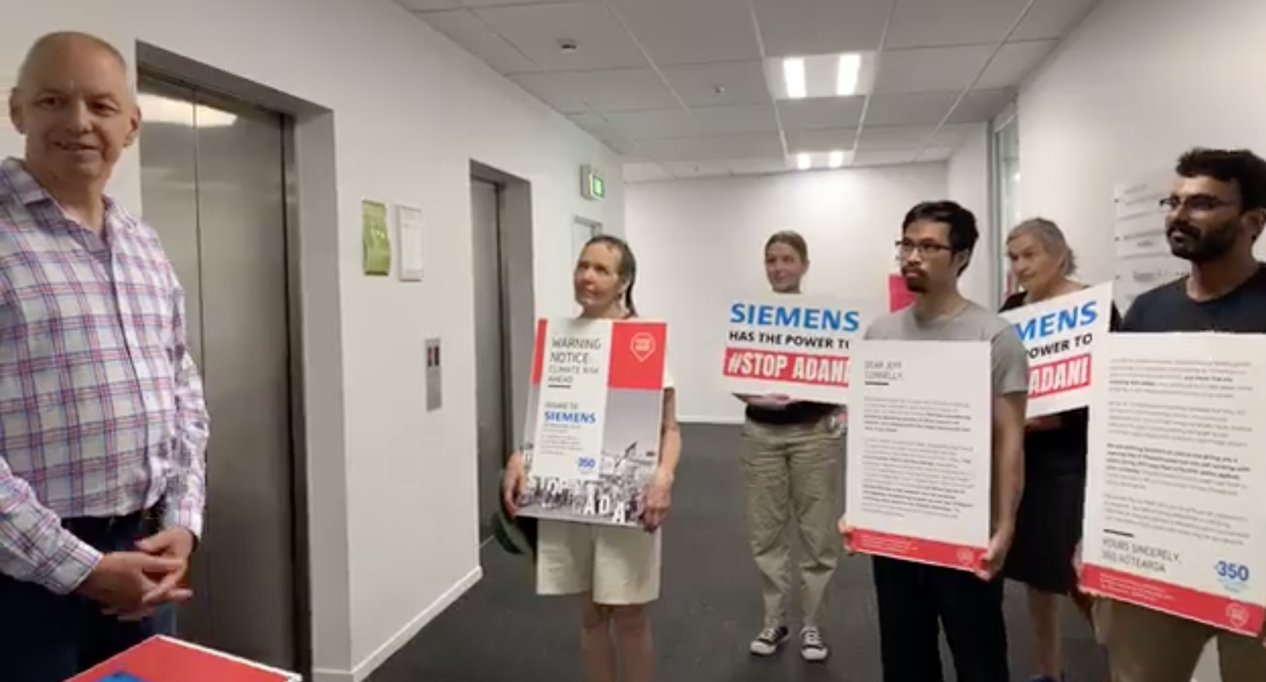Siemens NZ CEO Paul Ravlich receiving 350 Aotearoa's warning notice
