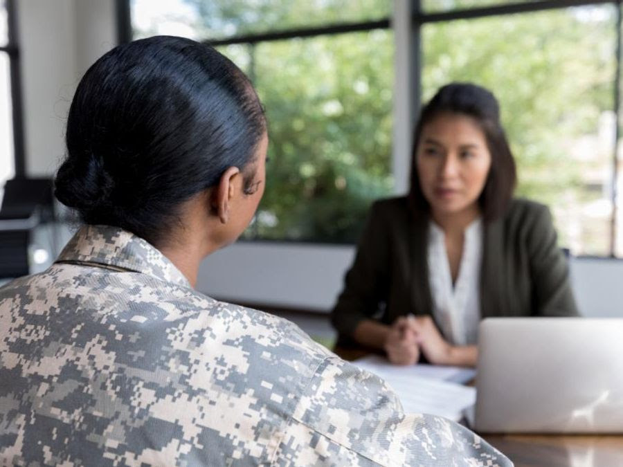 Back of woman's head sitting at table facing woman during interview