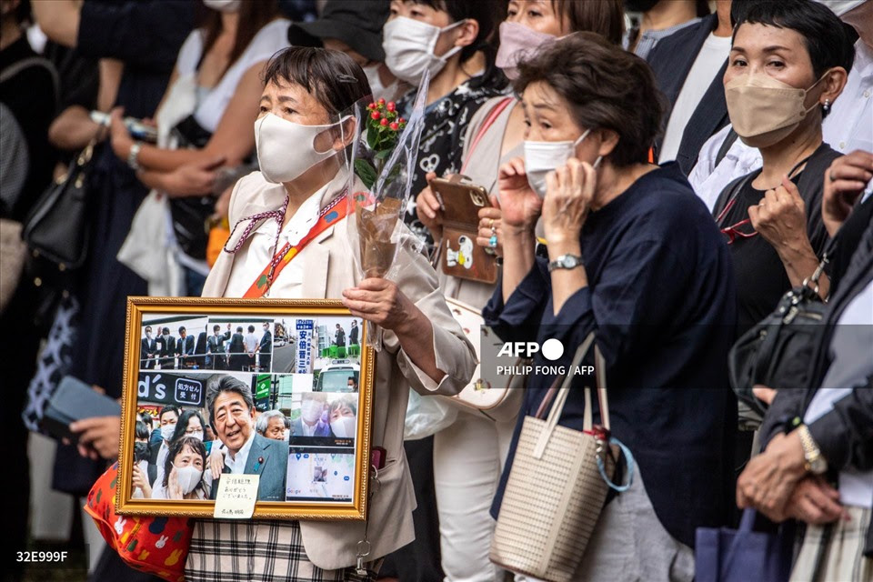 Người dân mang theo ảnh ông Abe Shinzo khi đi đưa tiễn ông ngày 12.7. Ảnh: AFP