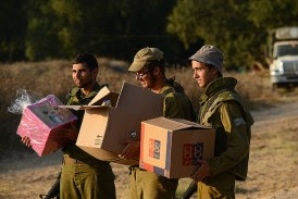 Israeli soldiers receiving food packages at a field near the border with Gaza.