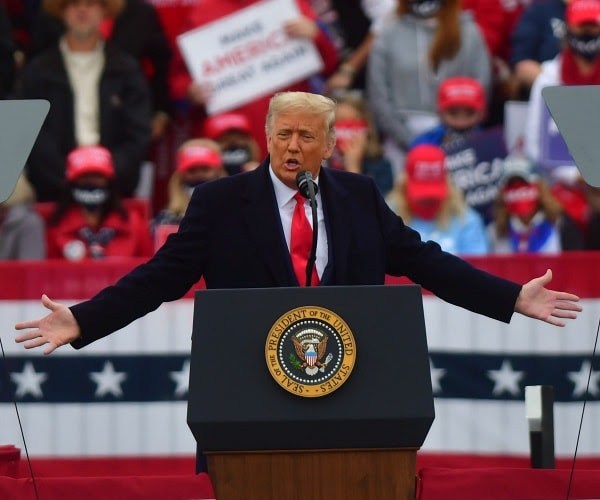 Trump stands in a power pose at a rally