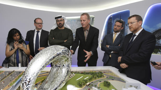 Emirati Minister of Cabinet Affairs Mohammed al-Gergawi, 3rd left, listens to architect Shaun Killa, center, who won the competition for the design. as he describes the concept of the &quot;Museum of the Future&quot; in front of the project&#39;s model at the UAE Prime Minister Office in Dubai, United Arab Emirates, Wednesday, March 4, 2015. Al-Gergawi told reporters Wednesday the museum in Dubai will showcase innovations in design and technology, in fields such as transportation, health and education. (AP Photo/Kamran Jebreili)