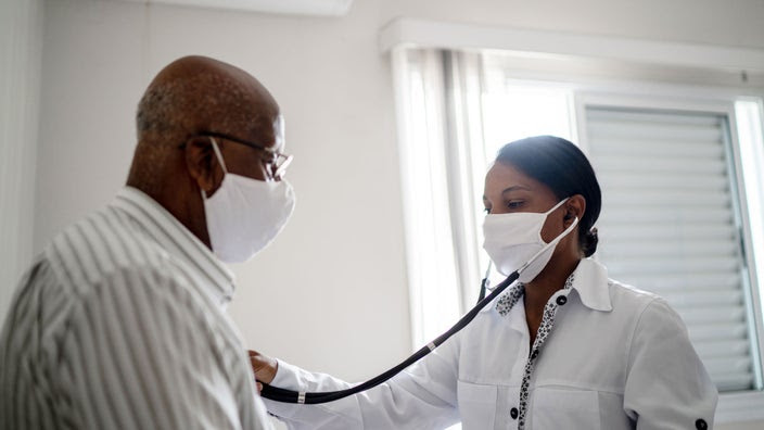 Doctor checks heartbeat of a senior man.