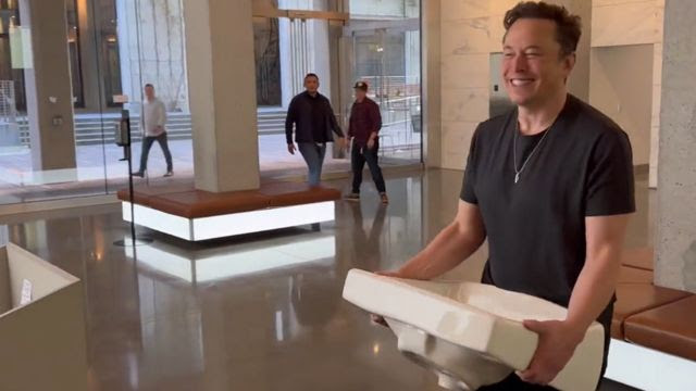 Elon Musk carrying a sink into Twitter HQ.
