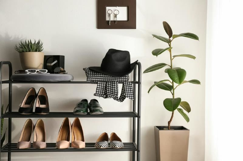 A shoe rack with shoes and a hat Description automatically generated