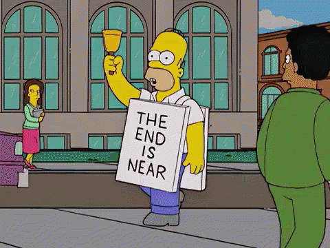 Homer Simpson wearing a "The End Is Near" sign and ringing a bell.