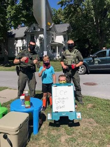 Two kids stand at their lemonade stand for a picture with two ECOs