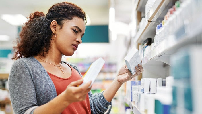 A woman browses the shelves of a pharmacy.