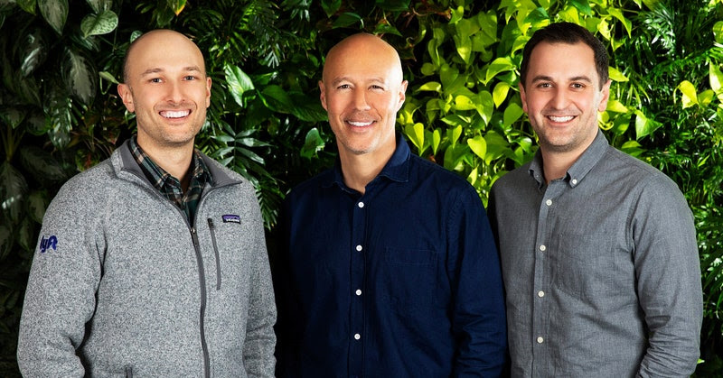L-R: Logan Green, David Risher, and John Zimmer standing in front of a wall of plants