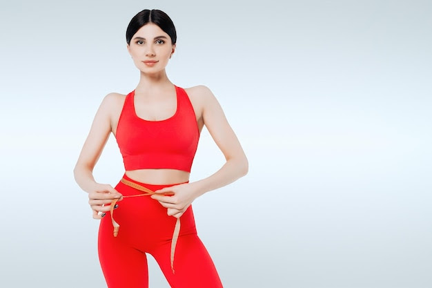 Concept of healthy eating fitness woman measuring waist