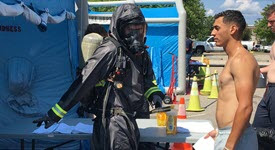 responders in the field help decontaminate a person