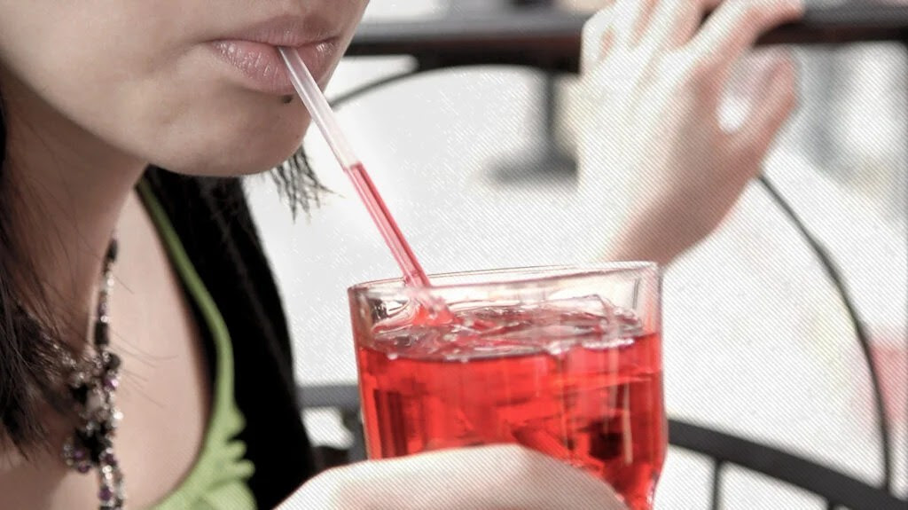 A person drinking cranberry juice to help treat or prevent a UTI.