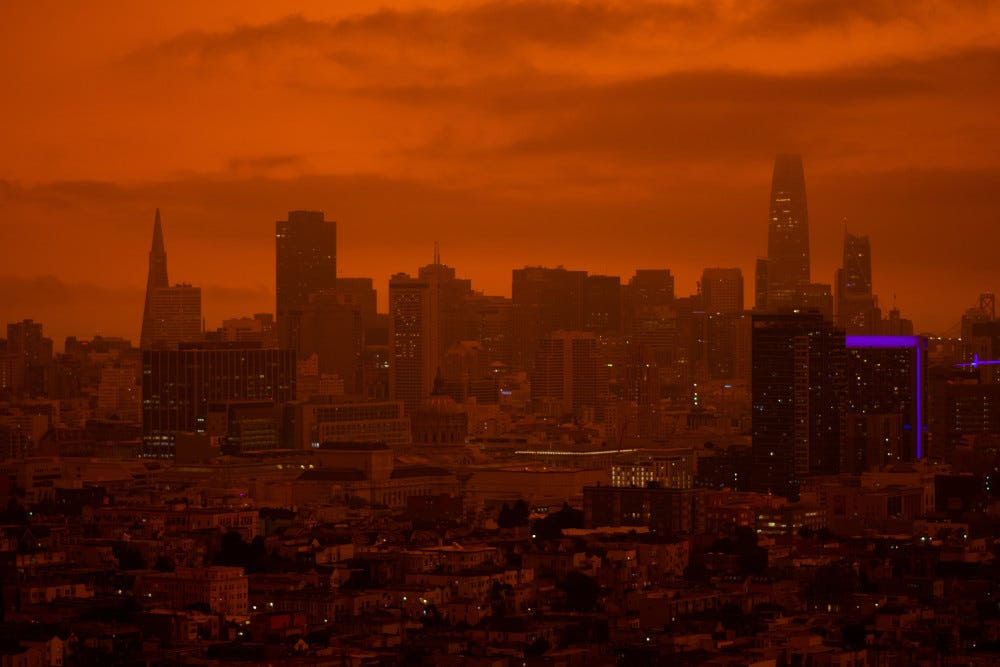 el cielo de una ciudad se vuelve naranja por causa del humo de los incendios