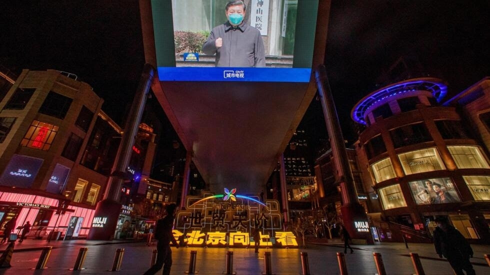 Hình ảnh Tập Cận Bình đi thăm Vũ Hán được chiếu trên màn ảnh rộng trước một trung tâm thương mại ở Bắc Kinh, Trung Quốc, ngày 10/03/2020