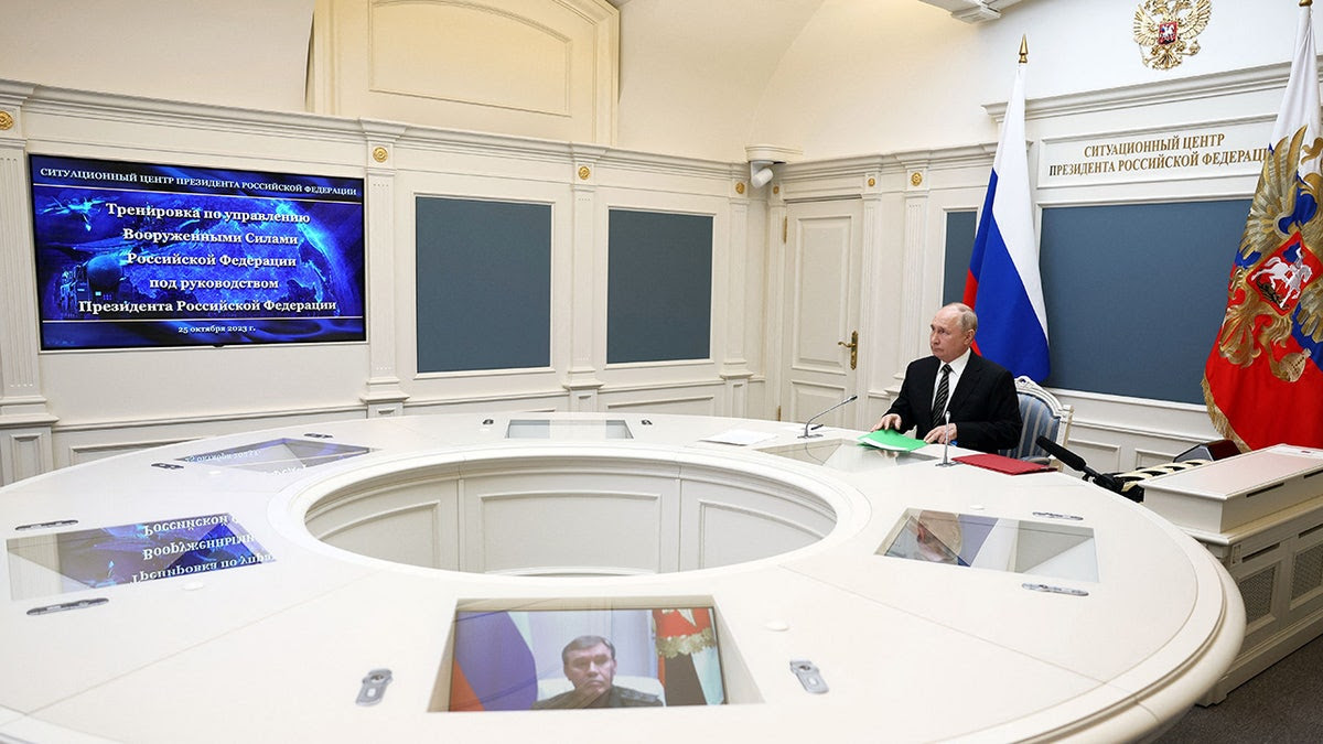 Putin looks on to military drill