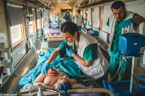 El equipo médico dentro de la unidad de cuidados intensivos (UCI) del tren médico de MSF monitorea y estabiliza a un paciente gravemente herido de guerra durante el viaje desde Pokrovsk, en el este de Ucrania, hasta Lviv, en el oeste de Ucrania.
