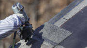 A roofer applies roofing tiles.