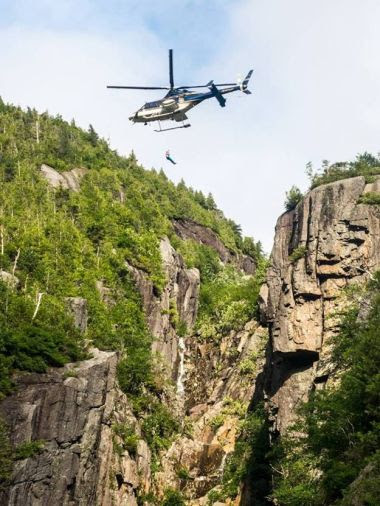 Helicopter flying over steep rock face