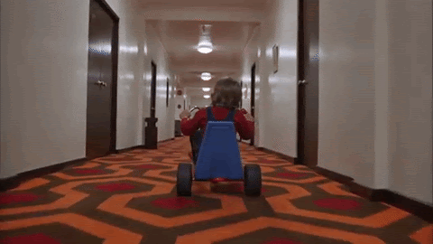 scene from The Shining with Jack riding a scooter down a coridoor