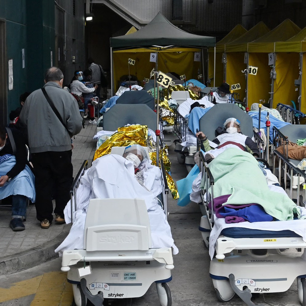 People lie in hospital beds outside the Medical Centre in Hong Kong, February 2022 (Credit: Peter Parks/Getty Images)