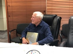 Gil holding plaque