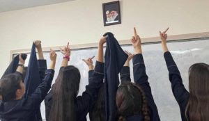 Iran: Schoolgirls give the finger to portrait of Khamenei and Khomeini