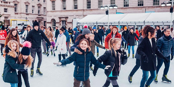 An image showing the ice rink at Somerset House and a crowd of laughing children