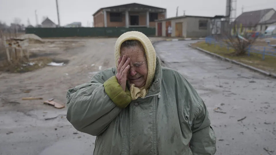 A woman cries outside houses damaged by an airstrike in Gorenka, Ukraine.