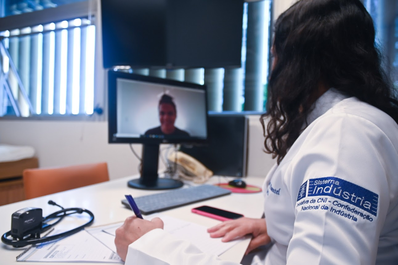 Médica da CNI realizando atendimento remoto de paciente