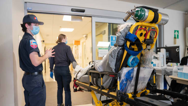 Paramedics escort a pandemic patient into the hospital on a stretcher