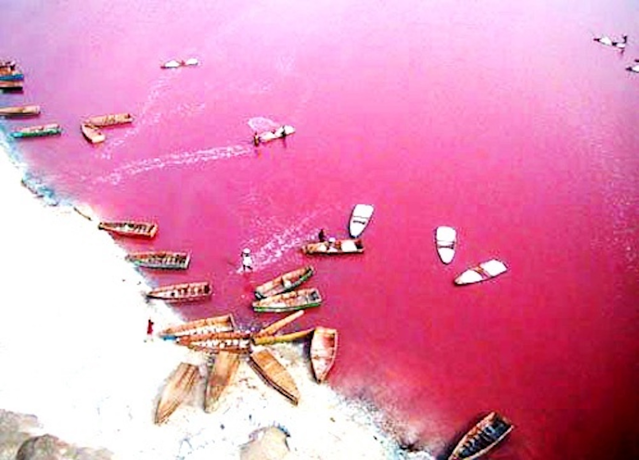 Este pequeño lago de solo 3 kilómetros cuadrados presenta un espectacular contraste entre su color rosado, el blanco de la sal en las orillas y las dunas doradas