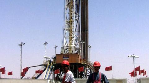 Workers in the oil fields near Talsint on August 23, 2000