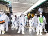 Workers wearing protective suits spray disinfectant as a precaution against the coronavirus at a market in Bupyeong, South Korea, Monday, Feb. 24, 2020. South Korea reported another large jump in new virus cases Monday a day after the the president called for &amp;quot;unprecedented, powerful&amp;quot; steps to combat the outbreak that is increasingly confounding attempts to stop the spread. (Lee Jong-chul/Newsis via AP)